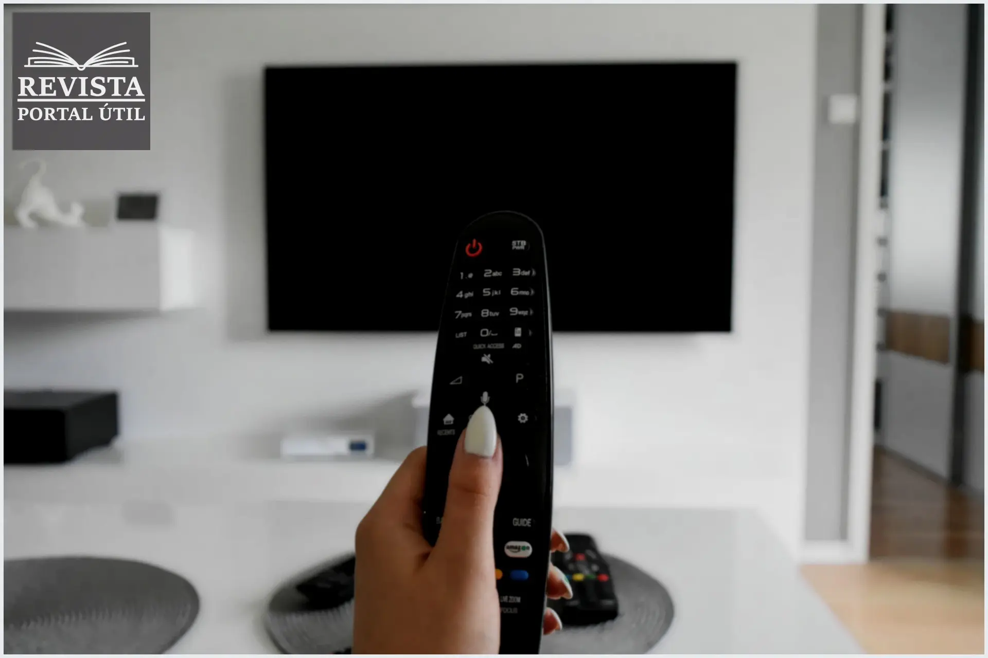 Como ver todos os programas da programação NET? Uma mão de uma mulher segurando um controle remoto de TV