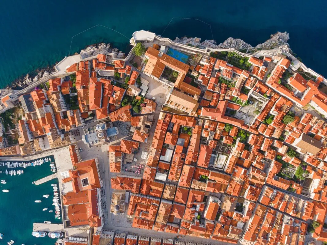 Vista aérea dos telhados vermelhos e das muralhas da cidade velha de Dubrovnik à beira do mar Adriático